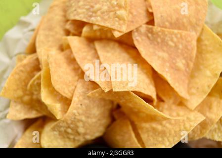 Pile of fried crisp tortilla corn chips in a basked on a table for snacking or dipping in salsa at a Tex-Mex restaurant, Fredericksburg, Texas, USA Stock Photo