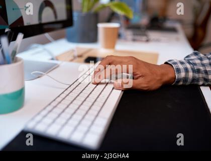 Close up of a man's hand typing on computer keyboard Stock Photo