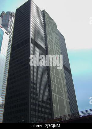 Chicago, USA - April 19 2016: A dark tall office building in Chicago. The skyscraper stands on the Chicago River. Stock Photo