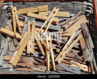 Old and new clothes pins in a basket Stock Photo