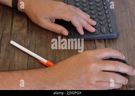 A person using a computer keyboard and mouse Stock Photo
