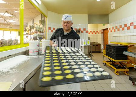 France, Meuse, Commercy, Thierry Zins handles a tray of madeleines to put it on the trolley in the shop and madeleine workshop of Commercy La Boite à Madeleines of the Zins brothers, madeleiniers since 1951 Stock Photo