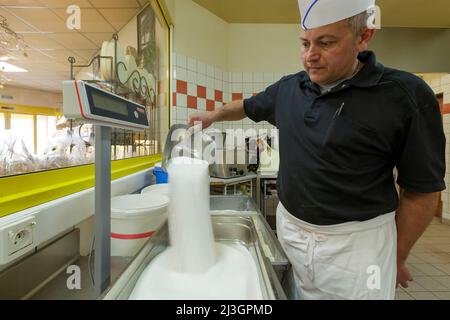 France, Meuse, Commercy, Thierry Zins weighs the sugar for the preparation of the madeleine dough in the shop and madeleine manufacturing workshop of Commercy La Boite à Madeleines of the Zins brothers, madeleiniers since 1951 Stock Photo