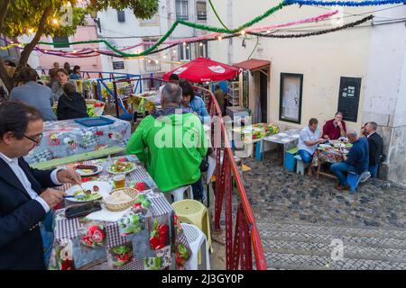 Portugal, Lisbon, Alfama district, people dining in the street during the Festas dos Santos Populares, (Festivals of Popular Saints) Stock Photo