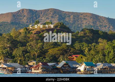 Philippines, Palawan, Calamianes Archipelago, Coron town, a giant sign announces the name of the town, on the hill overlooking the sea and the hotel on stilts Krystal Lodge Stock Photo