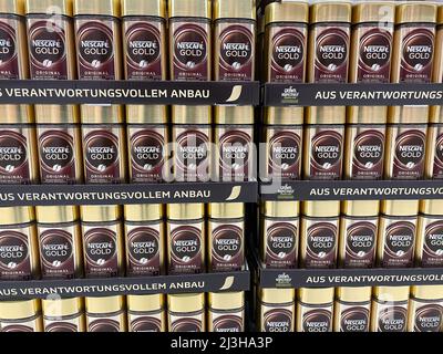 Viersen, Germany - April 5. 2022: Closeup of stacked highly visible wall many Nescafe gold glass jars in german supermarket Stock Photo