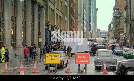 Glasgow, Scotland, UK 8th April, 2022.  West Nile street was closed off today as snow and hail fell down on Ira thriller borderlands filming in the city centre. Colin Morgan lies face down in the cold and wet for a close up  between snow showers and hides under a reflector during them.. Credit Gerard Ferry/Alamy Live News Stock Photo