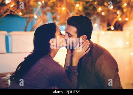 Thank you for a wonderful evening. Cropped shot of an affectionate young couple kissing while having a romantic dinner in a restaurant. Stock Photo