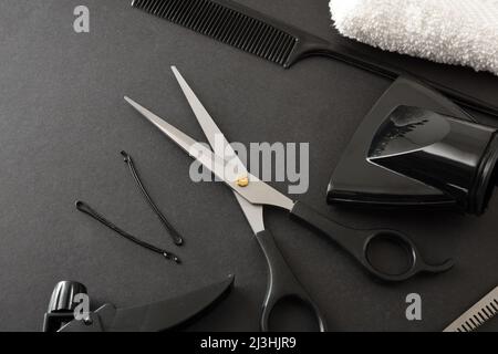 Set of hairdressing tools and styling on black table close up . Elevated view. Horizontal composition. Stock Photo