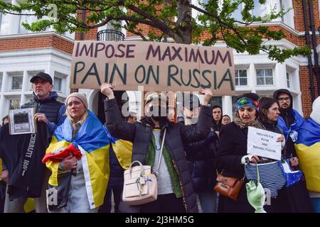 London, UK. 07th Apr, 2022. A demonstrator holds a placard saying 'Impose maximum pain on Russia' during the protest in solidarity with Ukraine outside the Russian Embassy in London. Hundreds of people gathered outside the embassy and dumped pans, clothing, toys, appliances and other household items, in response to the looting by Russian soldiers in Ukraine. Credit: SOPA Images Limited/Alamy Live News Stock Photo