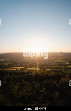 sun during sunset over green landscape Stock Photo