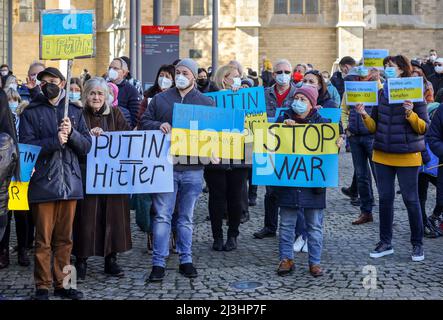 Wesel, North Rhine-Westphalia, Germany - Demonstration against Putin's war in Ukraine. Peace demonstration and solidarity rally for Ukraine at the Grosser Markt in Wesel. An old woman holds a banner PUTIN = HITLER. In times of corona pandemic all demonstrators wear masks. Stock Photo