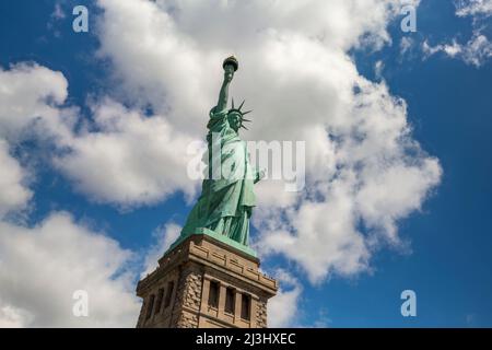 LIBERTY ISLAND, New York City, NY, USA, Statue of Liberty and a dramatic sky Statue of Liberty against blue sky with beautiful cloud background Stock Photo