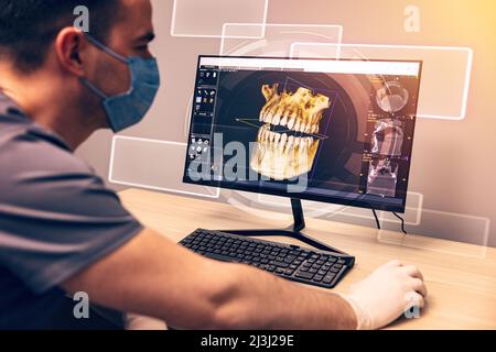 Attentive dentist examining an x-ray on computer in dental clinic Stock Photo