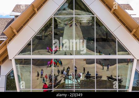 Windows of the Old Faithful Visitor Education Center look out on the iconic geyser Yellowstone National Park, USA [No model releases; editorial licens Stock Photo