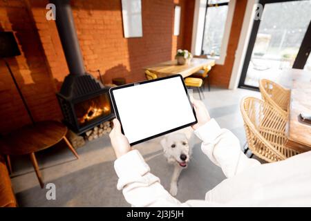 Holding digital tablet on cozy living room background Stock Photo