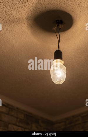 an old and dirty incandescent lamp hanging from the ceiling. High quality photo Stock Photo