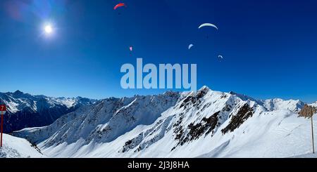 Ski resort Kappl in Paznaun valley, paragliders over the mountain peaks, snowy mountains, panoramic view to Ischgl, nature, mountains, winter, blue sky, Paznaun valley, Galtür, Ischgl, Kappl, Tyrol, Austria Stock Photo