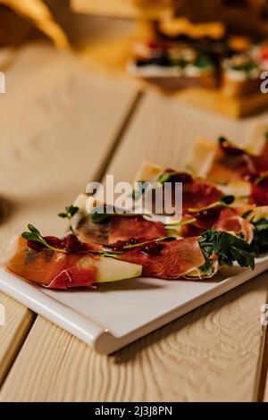 Appetizer with pear, blue cheese and prosciutto ham for holidays on a white plate Stock Photo