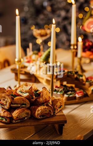 Croissant sandwich with cream cheese, salmon and arugula on a white plate, gray background, close-up. Healthy breakfast concept Stock Photo