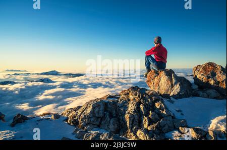 Mountaineer enjoying sunset on the top of Aggenstein in winter. Allgäu Alps, Bavaria, Germany, Europe Stock Photo