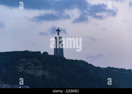 Jesus Christ monument by Tagus river in Lisbon, Portugal Against the evening sky Stock Photo