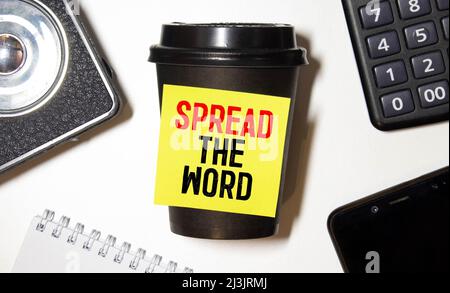 Handwriting text writing Spread The Word. Concept meaning Run advertisements to increase store sales many fold written on Tea in a Cup on the plain ba Stock Photo