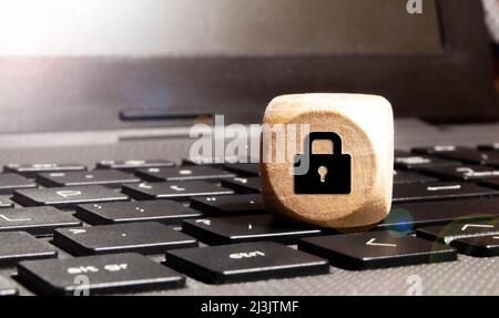 Wooden block with lock graphic on laptop keyboard. Computer security concept Stock Photo