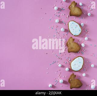 Easter holiday greeting card on pink background. Cute homemade cakes bunny, egg and decor. Copy space for your text Stock Photo