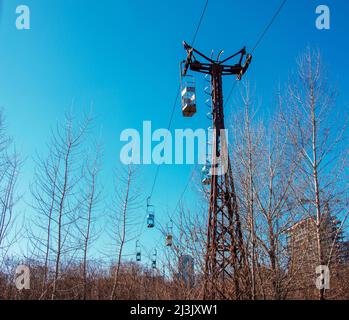 Old cable car in Dnepropetrovsk. Cable car cabins against the background of the blue sky and the urban landscape. Stock Photo