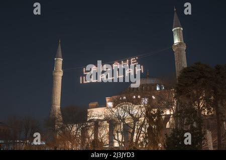 Ramadan in Istanbul. Mahya between the minarets of Hagia Sophia or Ayasofya. There is no god but Allah on the text. Stock Photo