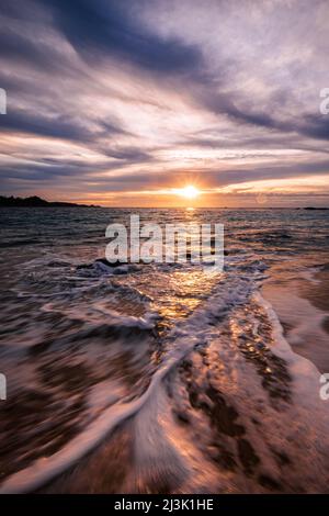 Receding waves at sunset in Carmel CA overlooking Point Lobos. Stock Photo