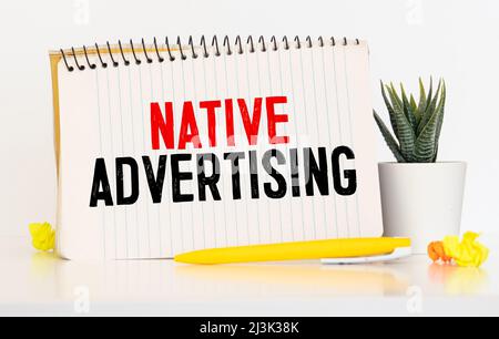 Text sign showing Native Advertising. Conceptual photo Online Paid Ads Match the Form Function of Webpage Scissors and writing equipments plus plain s Stock Photo