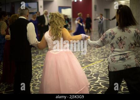 Dancing at meeting of old friends. Score in ball gowns.