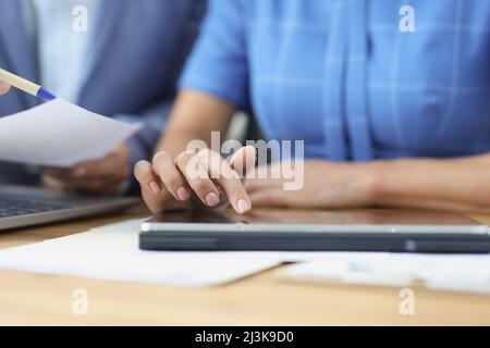 Business people talking using digital tablet sitting at office table Stock Photo