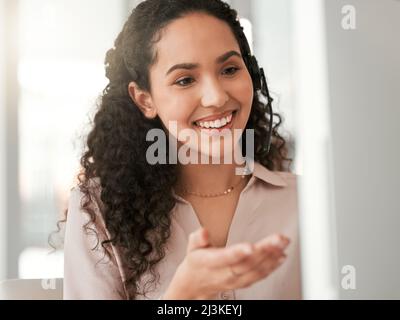 All you need is a friendly call center agent. Shot of a young female call center agent in an office at work. Stock Photo