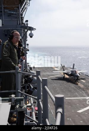 220406-N-TT639-1050 PACIFIC OCEAN (April 6, 2022) – Air Force Lt. Gen. Eric Fick, program executive officer for the F-35 Lightning II joint program, F-35 Joint Program Officer (JPO), observes flight operations from vulture’s row aboard amphibious assault ship USS Tripoli (LHA 7), April 6. Fick and other distinguished visitors were aboard Tripoli for a tour and to observe the U.S. Marine Corps’ Lightning carrier concept demonstration. The Lightning carrier concept demonstration shows Tripoli and other amphibious assault ships are capable of operating as dedicated fixed-wing strike platforms whe Stock Photo