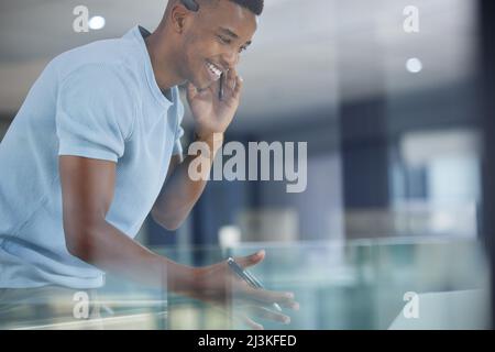 Making a success of the day by making all the sales. Shot of a young businessman working in a call centre. Stock Photo