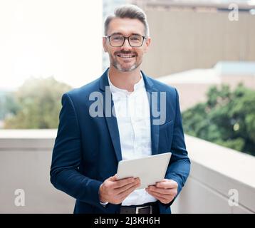 Aimed for the stars and I never missed. Portrait of a mature businessman using a digital tablet outside. Stock Photo