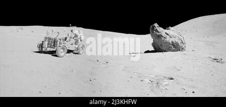 Mission Apollo 16:  John Young aiming the high-gain antenna at the Earth prior to sending TV signals. Shadow Rock at right and Smoky Mountain behind it. The stop at station 13 was to collect a series of samples from a permanently shadowed area. Shadow Rock, a 4-m-diameter boulder to the right in the photograph, was the location of the sampling.