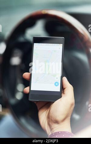 Know your place in the world. Closeup shot of a driver using his cellphone for directions. Stock Photo