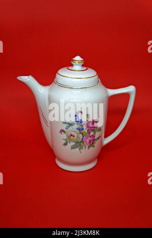 Vintage porcelain coffe pot on red background Stock Photo