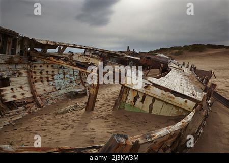Weathered shipwreck lying in sand dunes at Crow Point, at the mouth of the Taw and Torridge Rivers, near Barnstaple, Devon, Great Britain Stock Photo