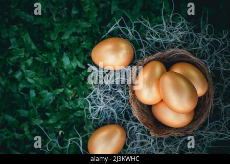 golden eggs on green grass to represent wealth and luck, easter day concept. Stock Photo