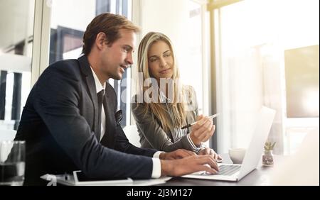 One hundred percent focused on their work. Shot of a two executives working together in an office. Stock Photo