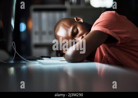 It can be tiring being the hardest worker. Cropped shot of a man falling asleep while working late at the office. Stock Photo