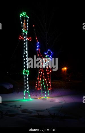 Illuminated Christmas decorations in a snowy park on a winter night; Stony Plain, Alberta, Canada Stock Photo