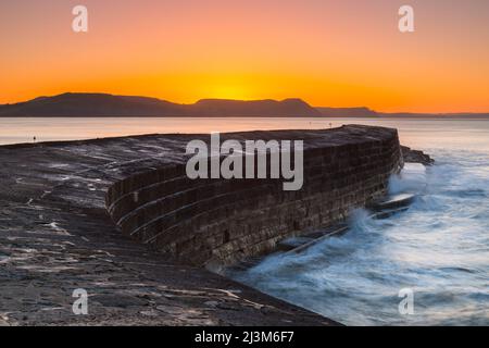 Lyme Regis, Dorset, UK.  9th April 2022.  UK Weather.  Clear skies during sunrise at the Cobb Harbour at Lyme Regis in Dorset on a cold frosty morning. Picture Credit: Graham Hunt/Alamy Live News Stock Photo