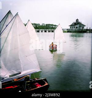 An eight year old boy heads to sail his small kid's sailboat in Manteo, North Carolina.; Manteo, North Carolina, United States. Stock Photo