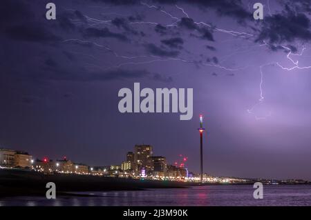 A dramatic bolt of lightning strikes lights up the sky over the  city of Brighton on a stormy summer's night on the south coast of the UK Stock Photo